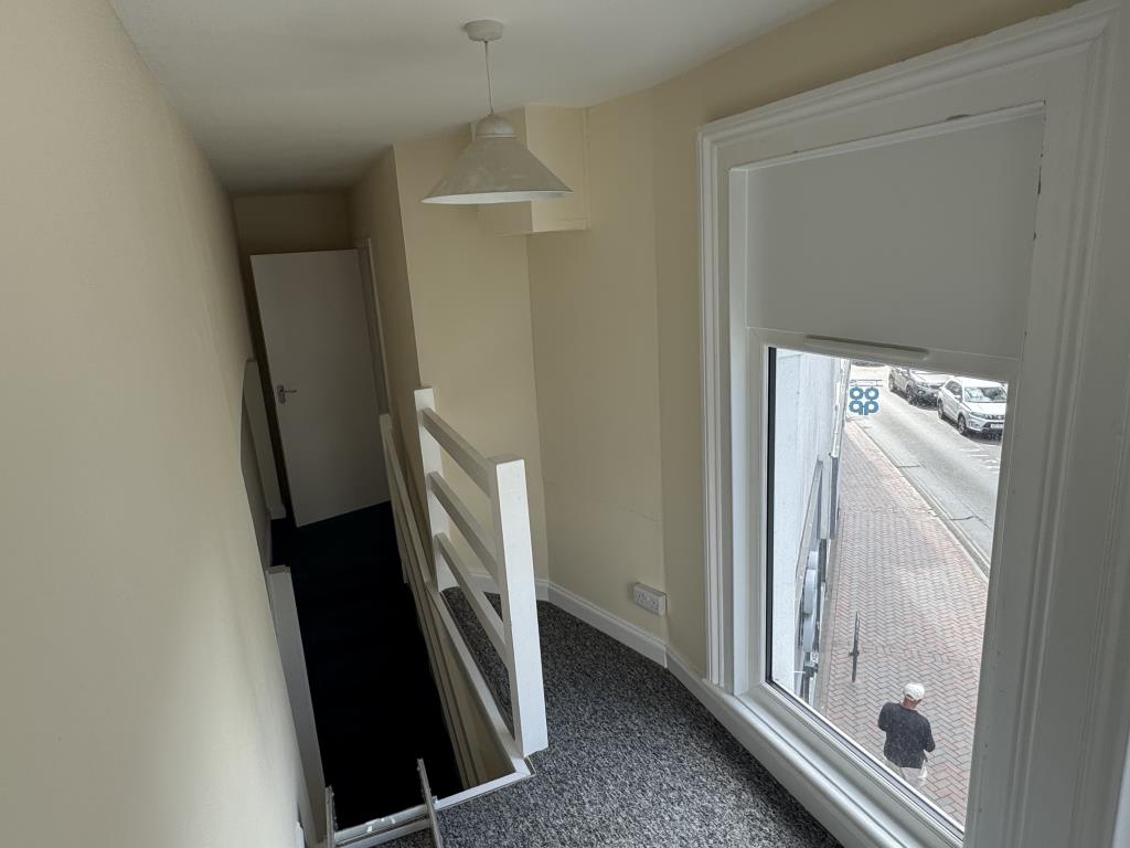 Lot: 152 - TWO-BEDROOM TOWN CENTRE FLAT FOR INVESTMENT OR OWNER OCCUPATION - View of stairs and window to Pier Street